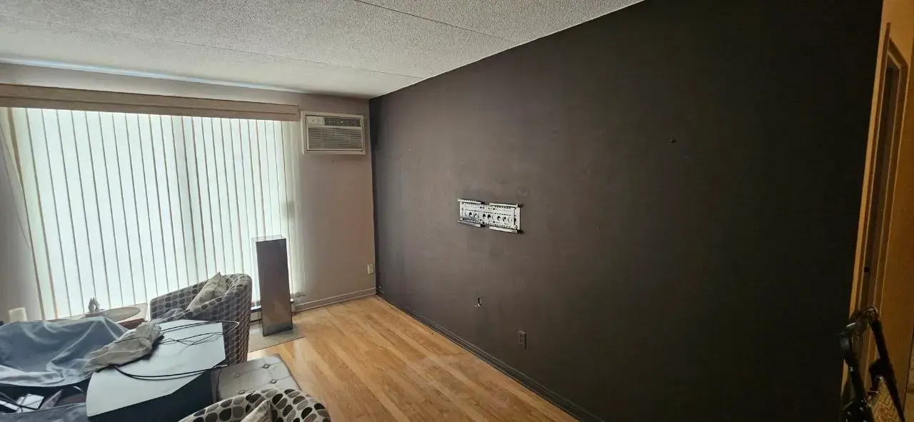 Accent wall before repainting — scuffed charcoal finish Windsor condo