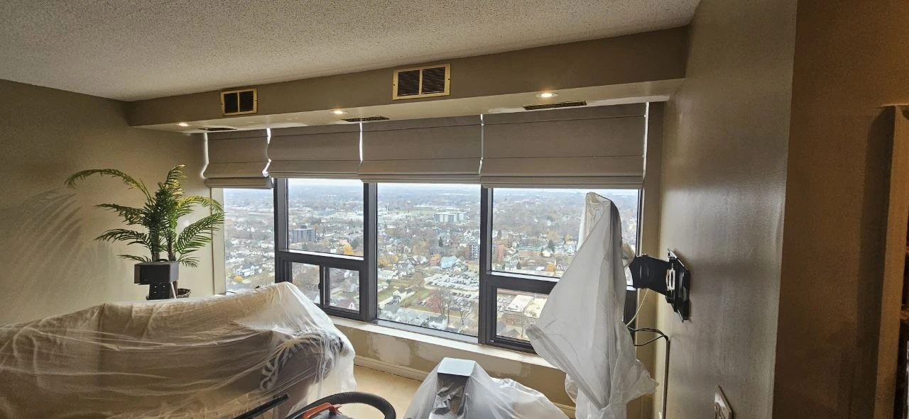 High-rise condo before repaint — grey walls, worn bulkhead and window sill, Windsor ON